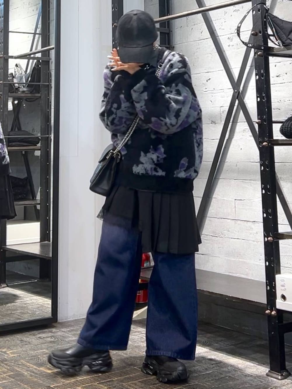 パープル系のデニムパンツ、ブラック系のニット/セーター、ブラック系のブーツを着用したレディースの冬コーディネートの3枚目の写真