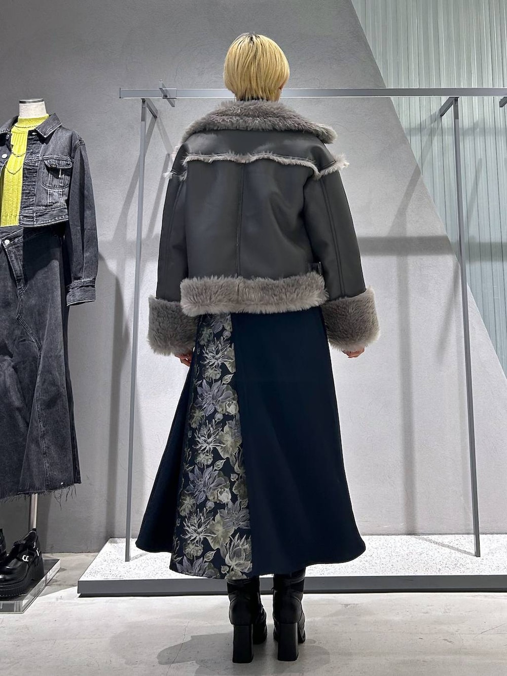 グレー系のムートンコート、ブラック系のブーツ、ブラック系のシャツ/ブラウスを着用したレディースの秋コーディネートの4枚目の写真