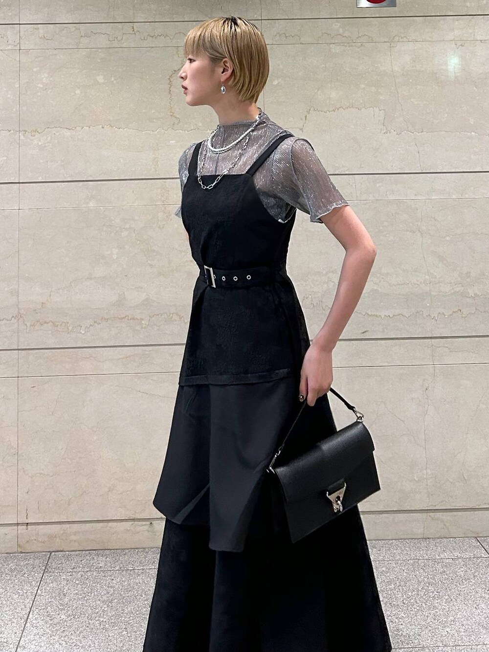 ブラック系のショルダーバッグ、ホワイト系のサンダル、ブラック系のワンピースを着用したレディースの春コーディネートの8枚目の写真