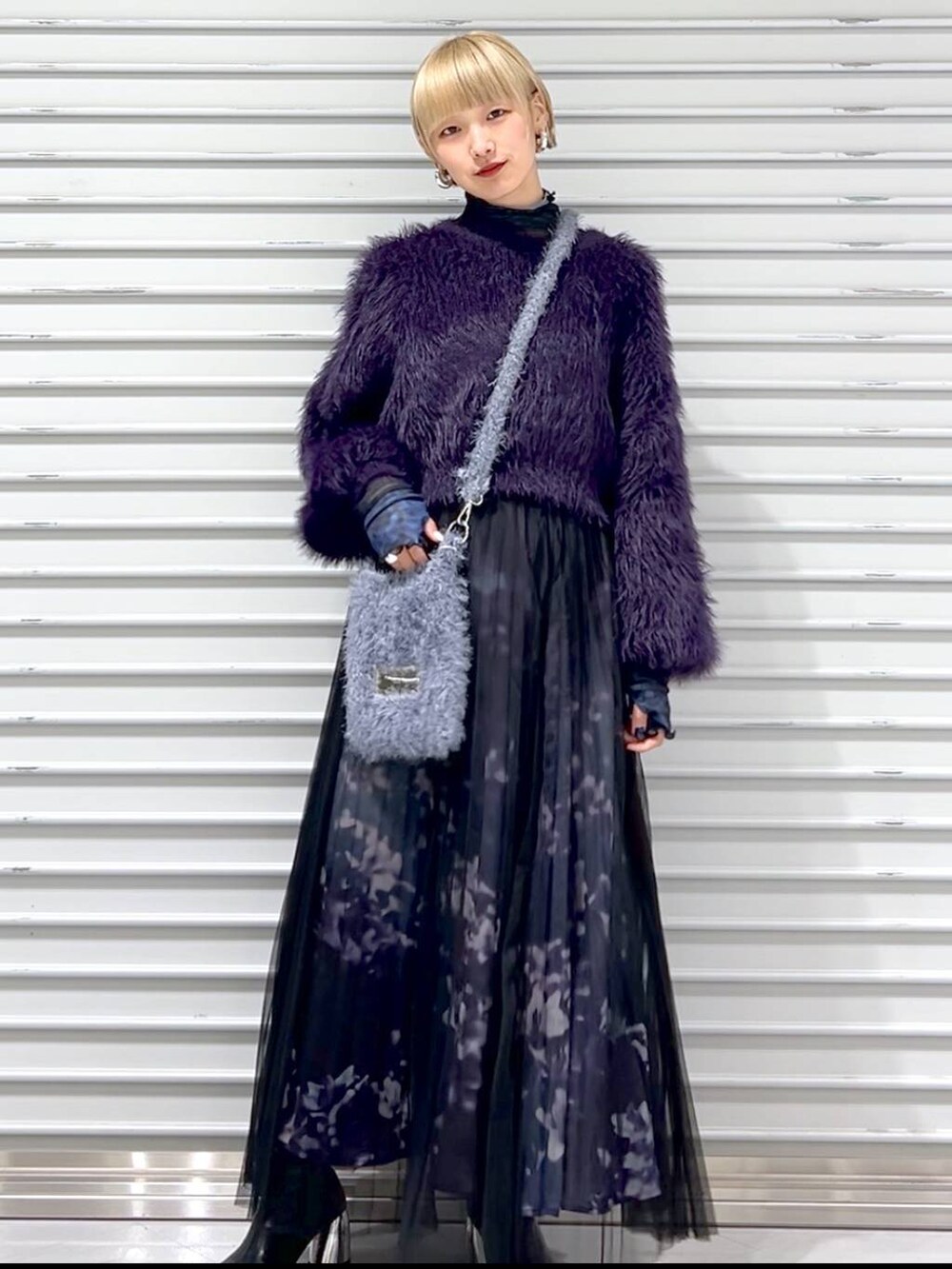 パープル系のニット/セーター、ブラック系のブーツ、グレー系のショルダーバッグを着用したレディースの秋コーディネートの4枚目の写真