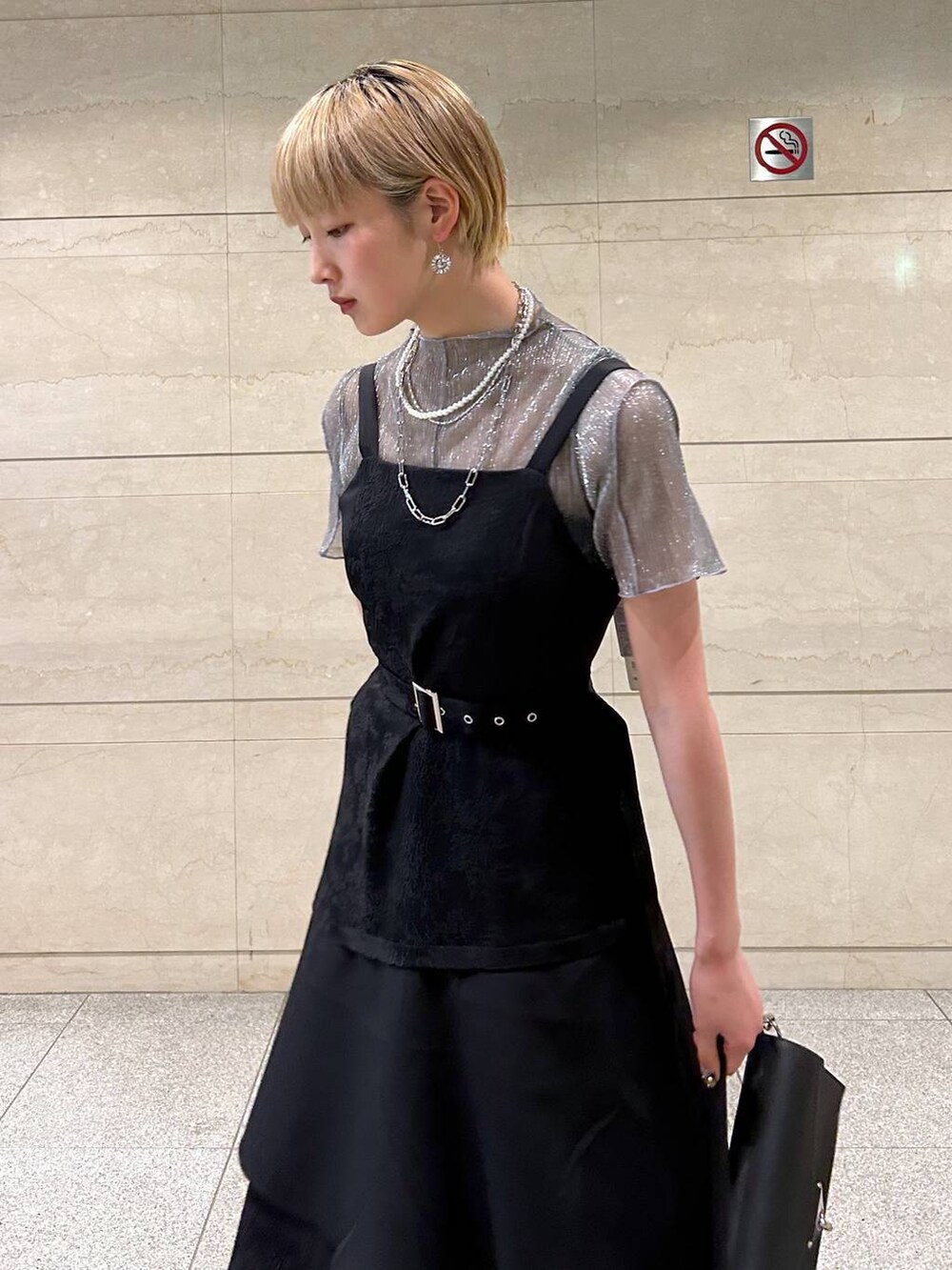 ブラック系のショルダーバッグ、ホワイト系のサンダル、ブラック系のワンピースを着用したレディースの春コーディネートの5枚目の写真