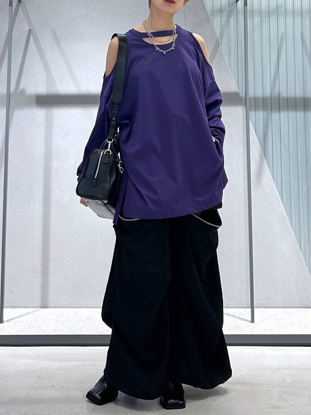 ブラック系のカーゴパンツ、ブラック系のボストンバッグ、パープル系のTシャツ/カットソーを着用したレディースの夏コーディネートの5枚目の写真