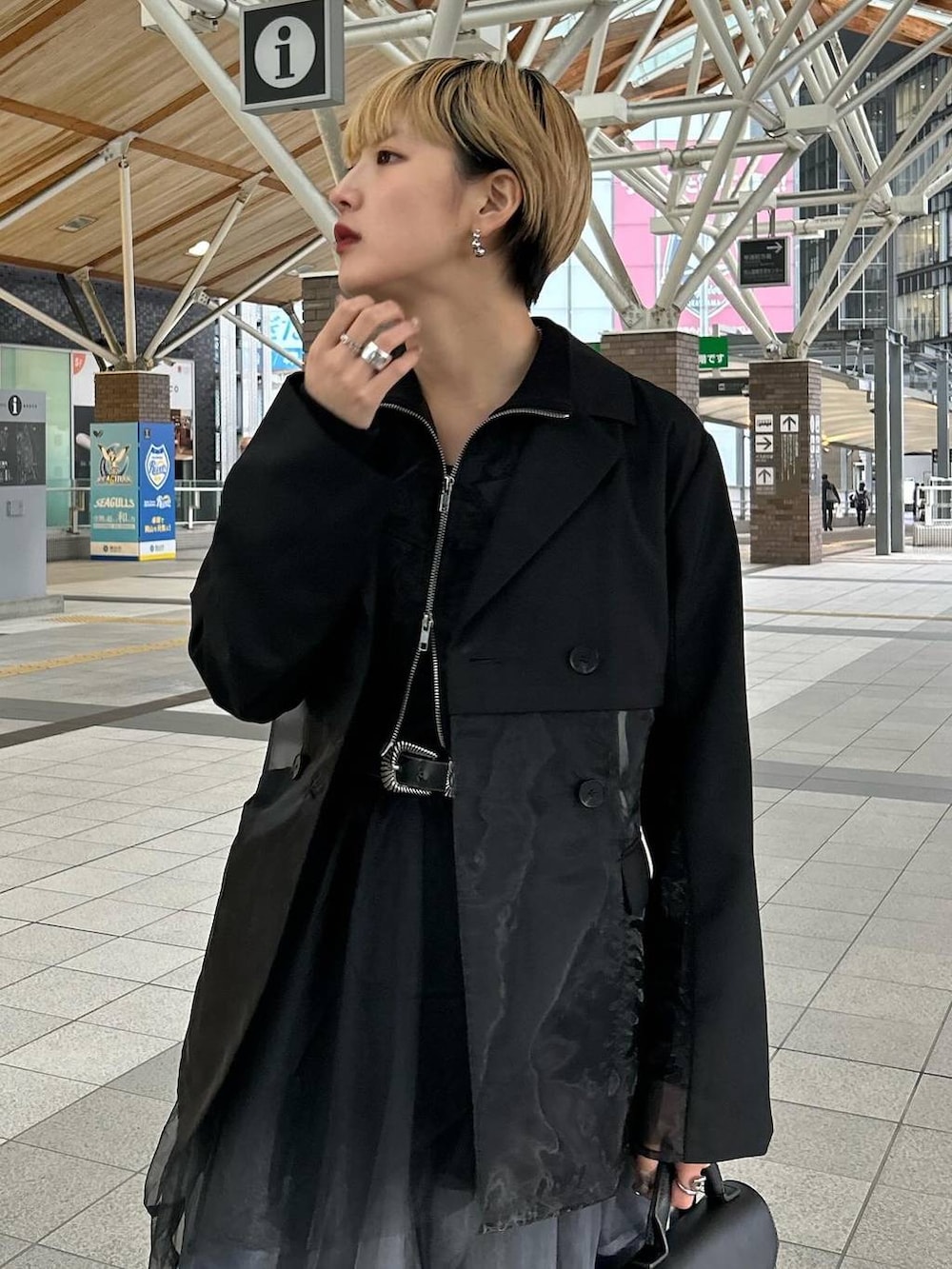 ブラック系のテーラードジャケット、グレー系のスカート、ブラック系のブーツを着用したレディースの春コーディネートの5枚目の写真