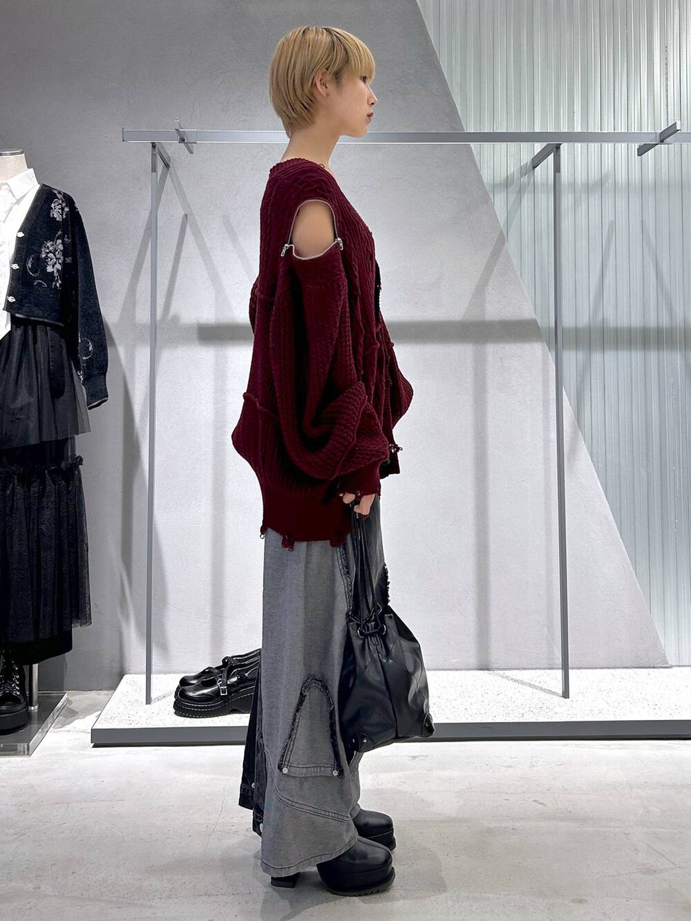 ブラック系のショルダーバッグ、ブラック系のデニムパンツ、ブルー系のタンクトップを着用したレディースの秋コーディネートの2枚目の写真