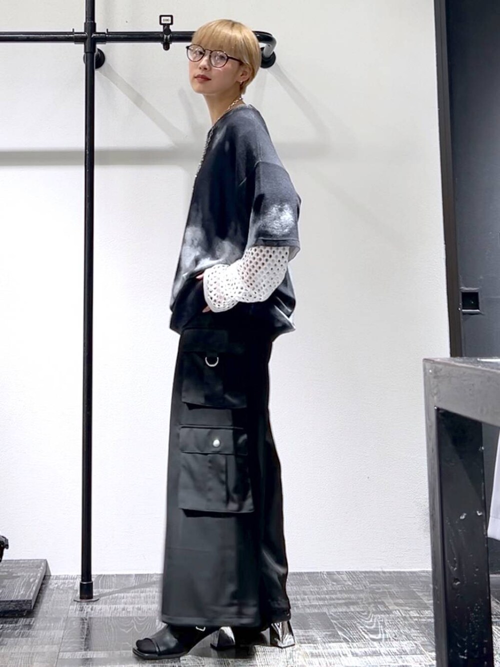 ブラック系のカーゴパンツ、ブラック系のサンダル、ホワイト系のTシャツ/カットソーを着用したレディースの春コーディネートの5枚目の写真