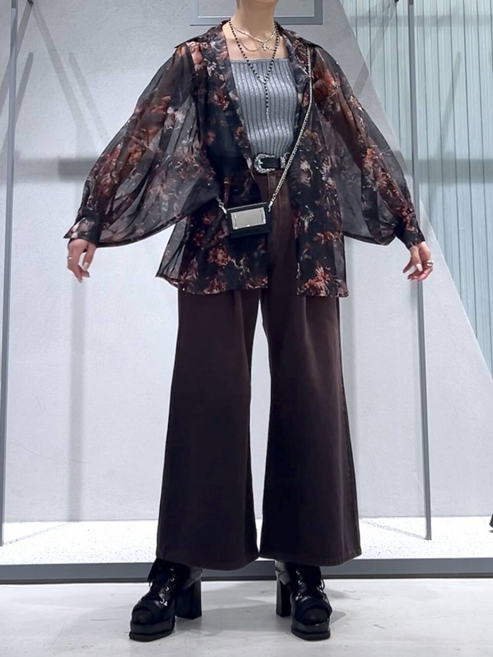 グレー系のタンクトップ、ブラック系のブーツ、オレンジ系のシャツ/ブラウスを着用したレディースの春コーディネートの4枚目の写真