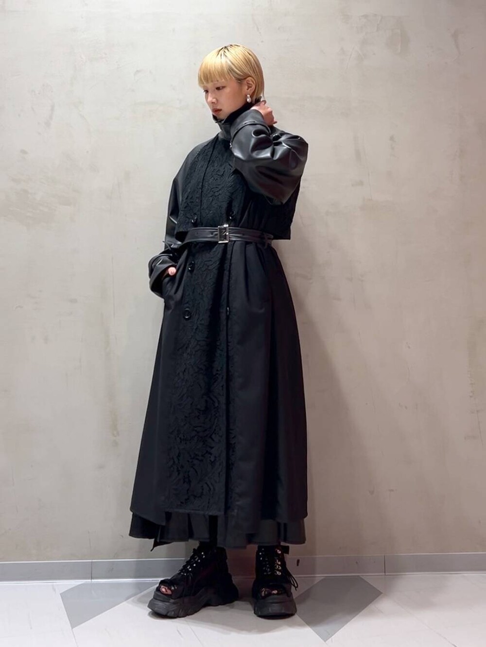 ブラック系のスカート、ブルー系のシャツ/ブラウス、ブラック系のトレンチコートを着用したレディースの秋コーディネートの6枚目の写真