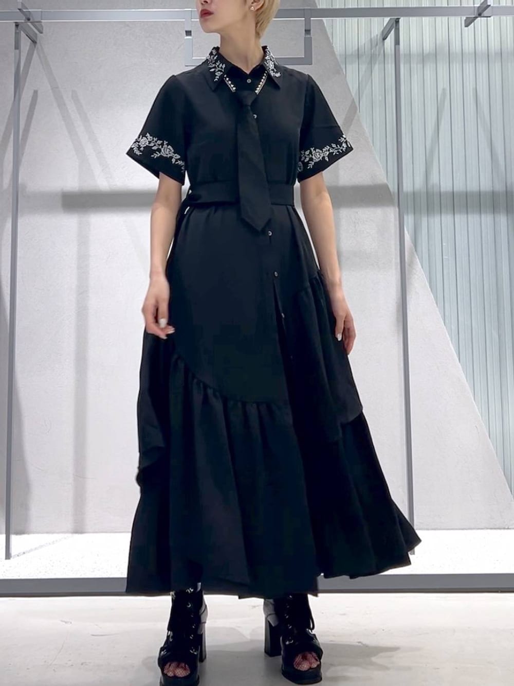 ブラック系のネクタイ、ブラック系のブーツ、ブラック系のスカートを着用したレディースの春コーディネートの6枚目の写真