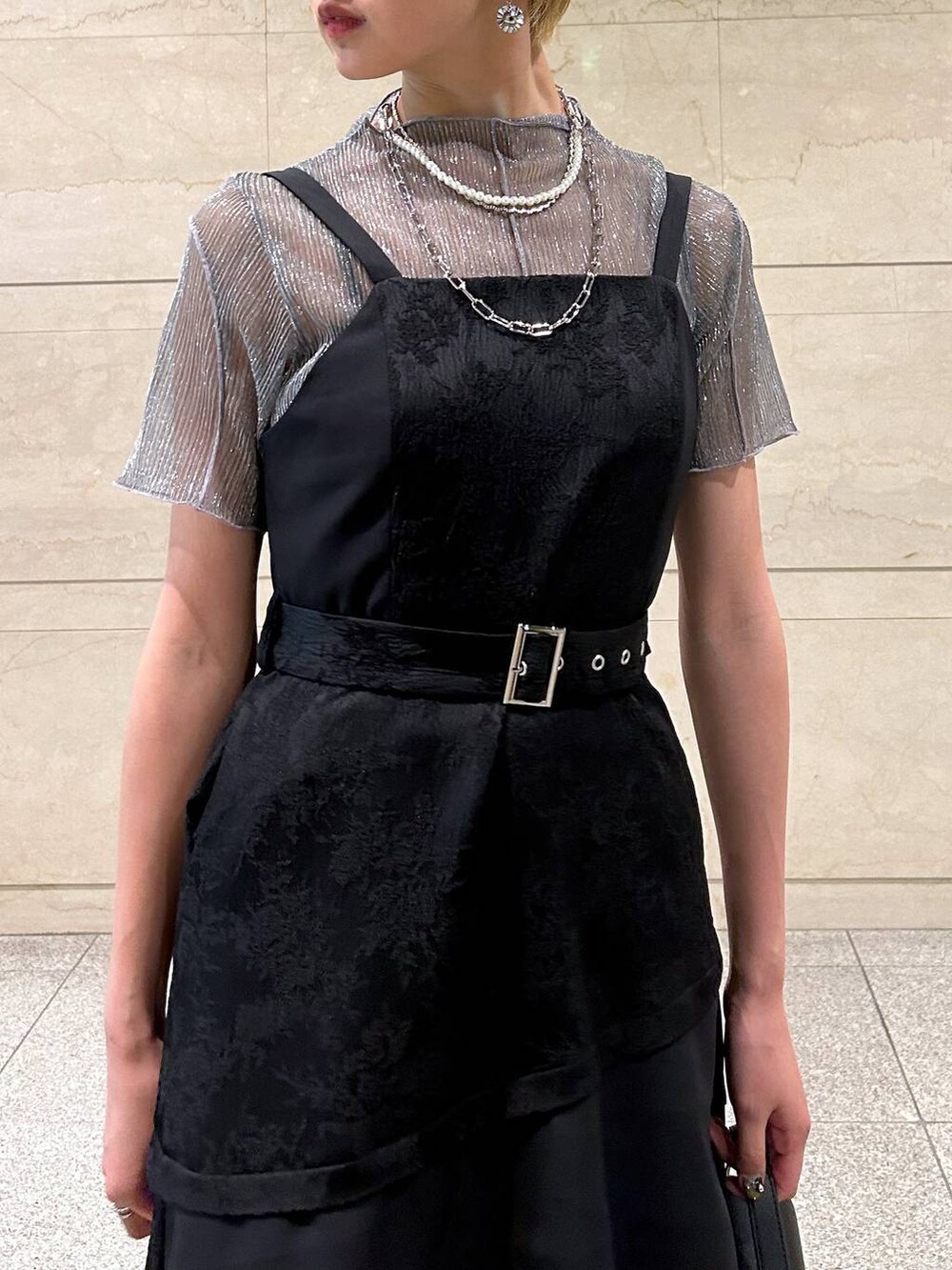 ブラック系のショルダーバッグ、ホワイト系のサンダル、ブラック系のワンピースを着用したレディースの春コーディネートの6枚目の写真