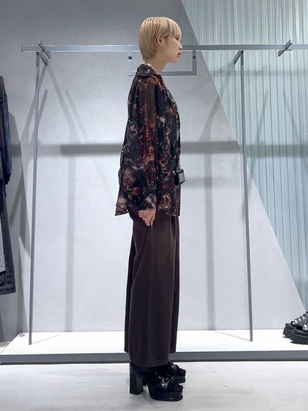 グレー系のタンクトップ、ブラック系のブーツ、オレンジ系のシャツ/ブラウスを着用したレディースの春コーディネートの2枚目の写真