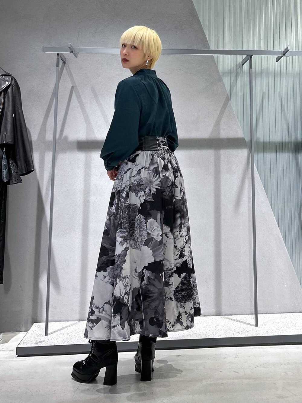 ブラック系のブーツ、ホワイト系のスカートを着用したレディースの秋コーディネートの2枚目の写真