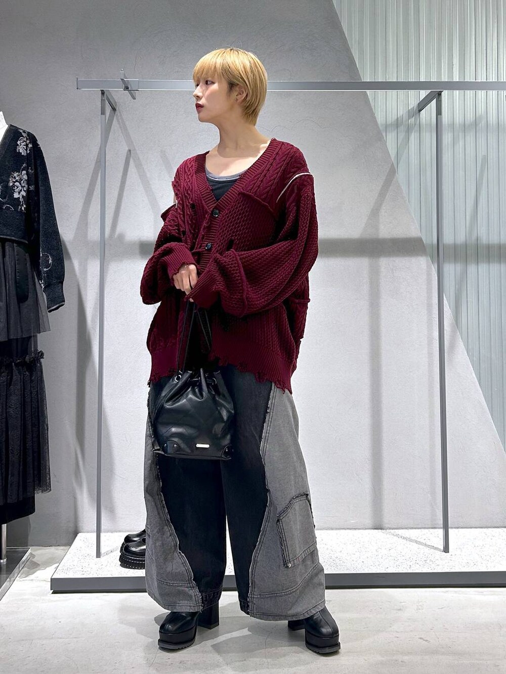 ブラック系のショルダーバッグ、ブラック系のデニムパンツ、ブルー系のタンクトップを着用したレディースの秋コーディネートの5枚目の写真