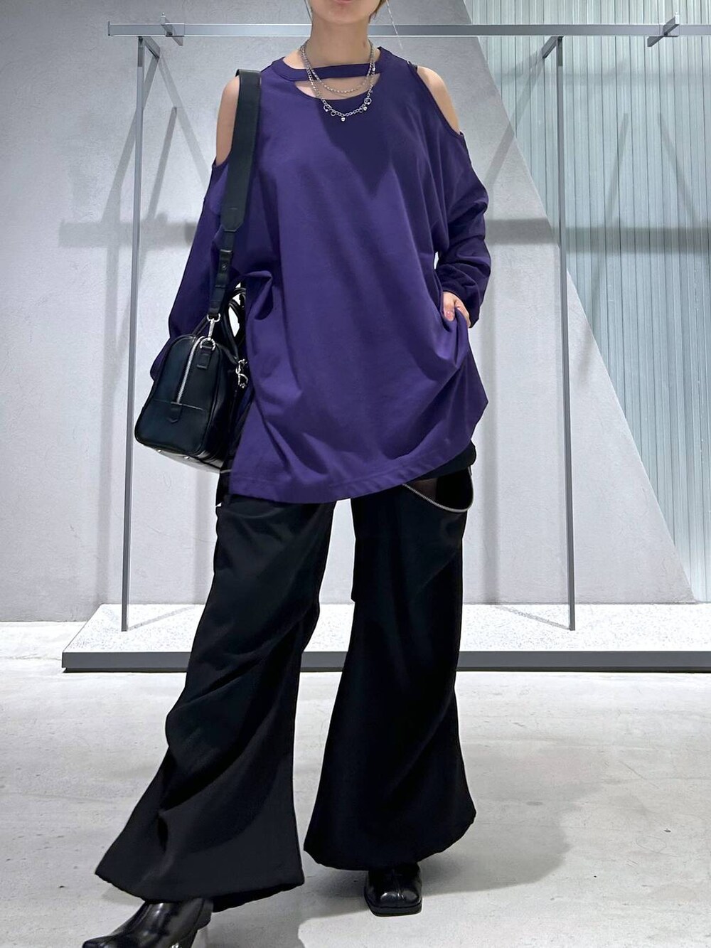 ブラック系のカーゴパンツ、ブラック系のボストンバッグ、パープル系のTシャツ/カットソーを着用したレディースの夏コーディネートの2枚目の写真