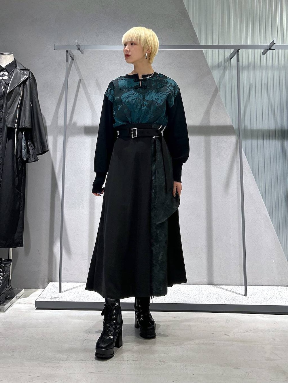 ブラック系のブルゾン、ブラック系のブーツ、グリーン系のスウェットを着用したレディースの秋コーディネートの2枚目の写真