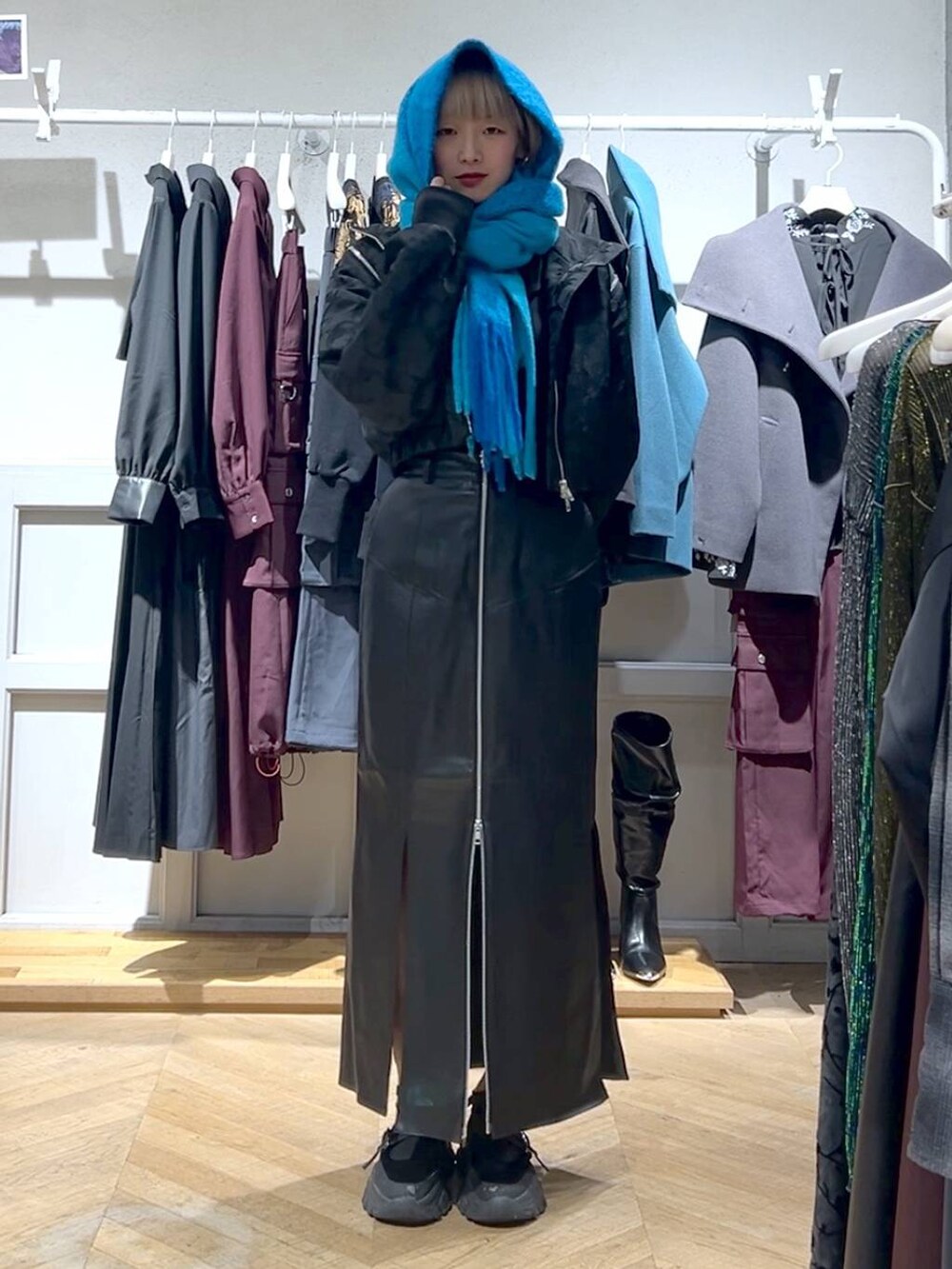 ブラック系のブルゾン、ブラック系のスカート、ブルー系のマフラーを着用したレディースの秋コーディネートの4枚目の写真