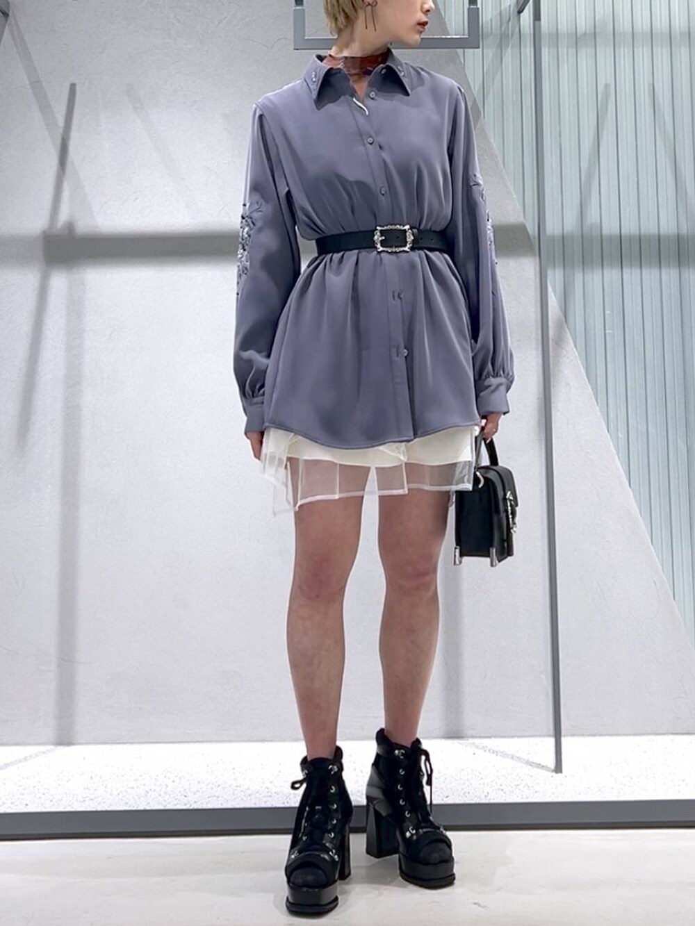 ブラック系のショルダーバッグ、パープル系のシャツ/ブラウス、ブラック系のブーツを着用したレディースの春コーディネートの2枚目の写真