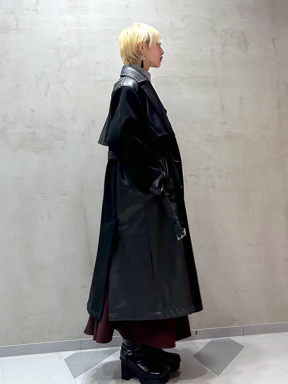 ホワイト系のニット/セーター、ブラック系のチェスターコート、レッド系のワンピースを着用したレディースの秋コーディネートの2枚目の写真