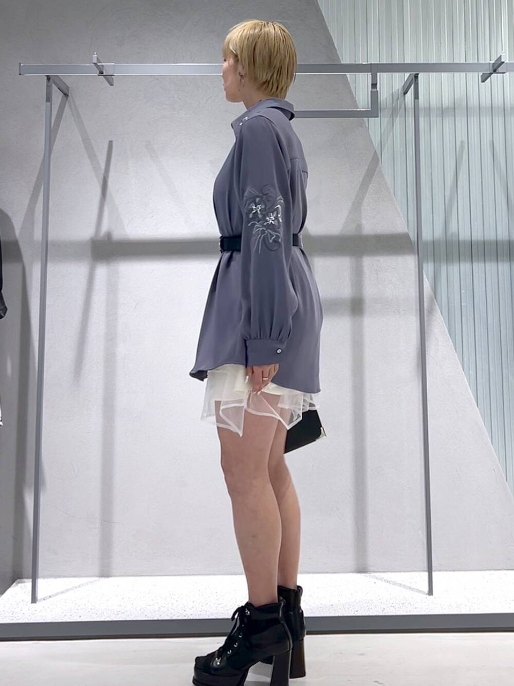 ブラック系のショルダーバッグ、パープル系のシャツ/ブラウス、ブラック系のブーツを着用したレディースの春コーディネートの6枚目の写真