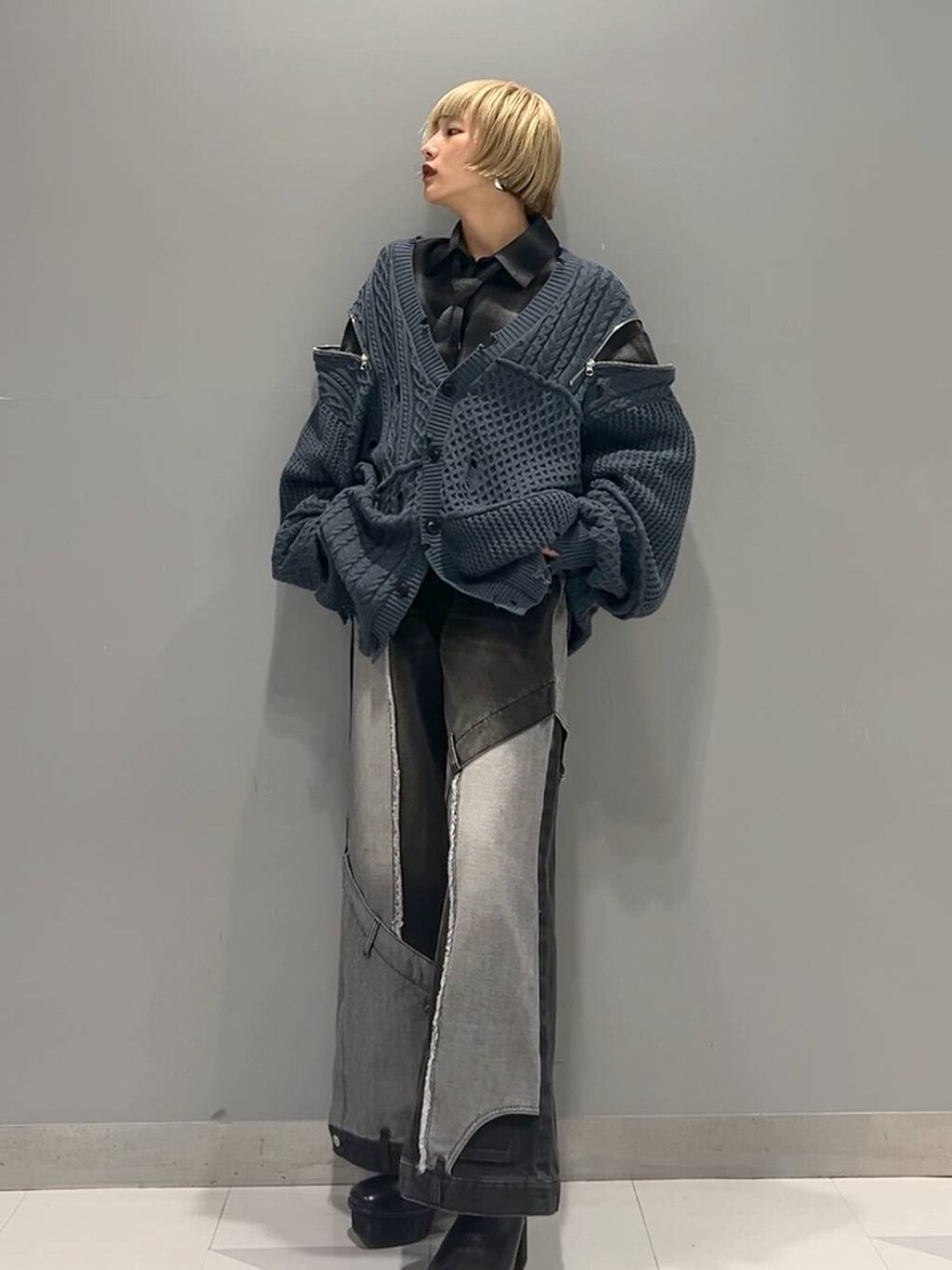 ブラック系のデニムパンツ、ブルー系のカーディガン/ボレロ、ブラック系のブーツを着用したレディースの秋コーディネートの5枚目の写真