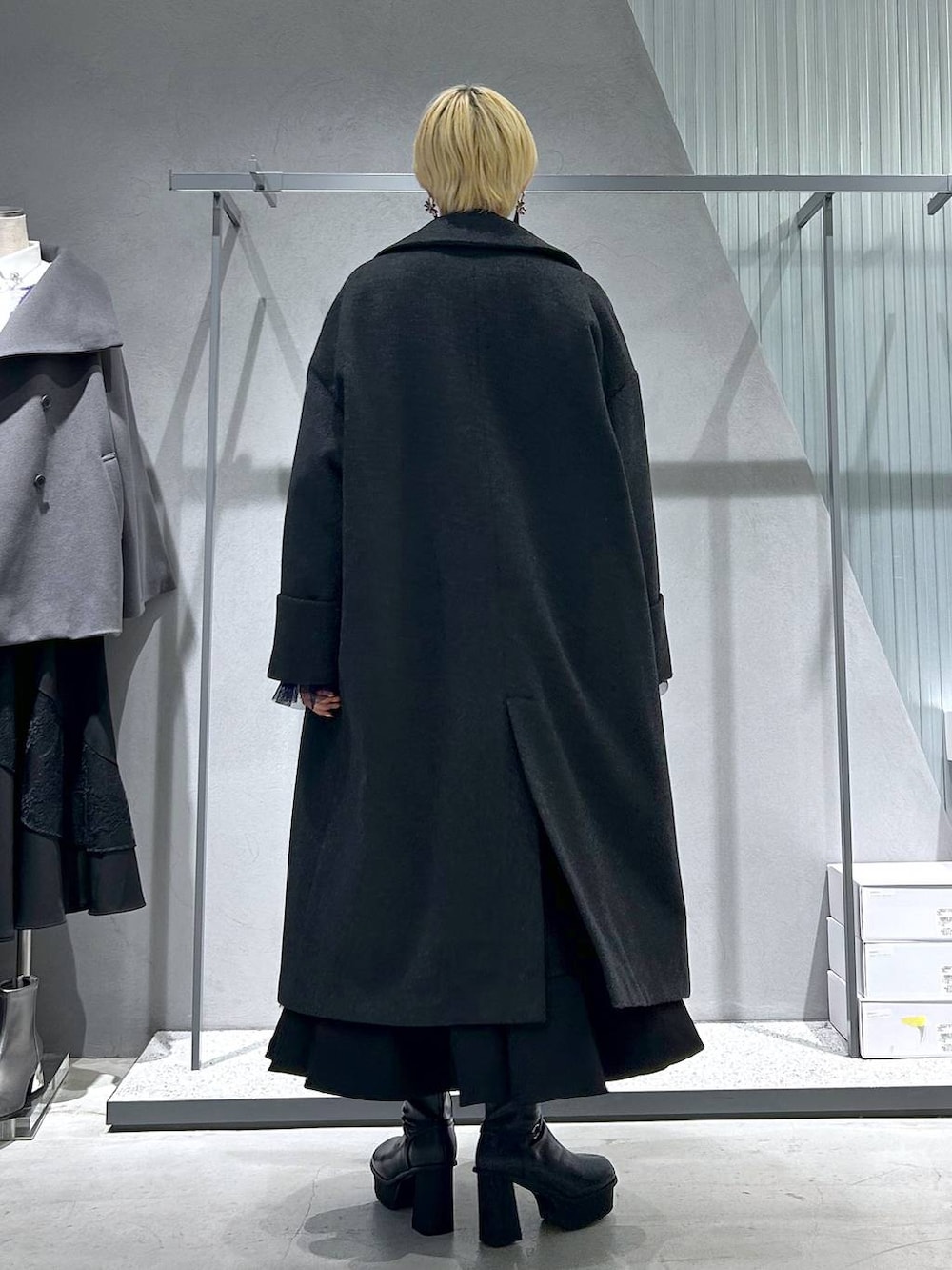 グレー系のチェスターコート、パープル系のカーディガン/ボレロ、グレー系のブーツを着用したレディースの秋コーディネートの4枚目の写真