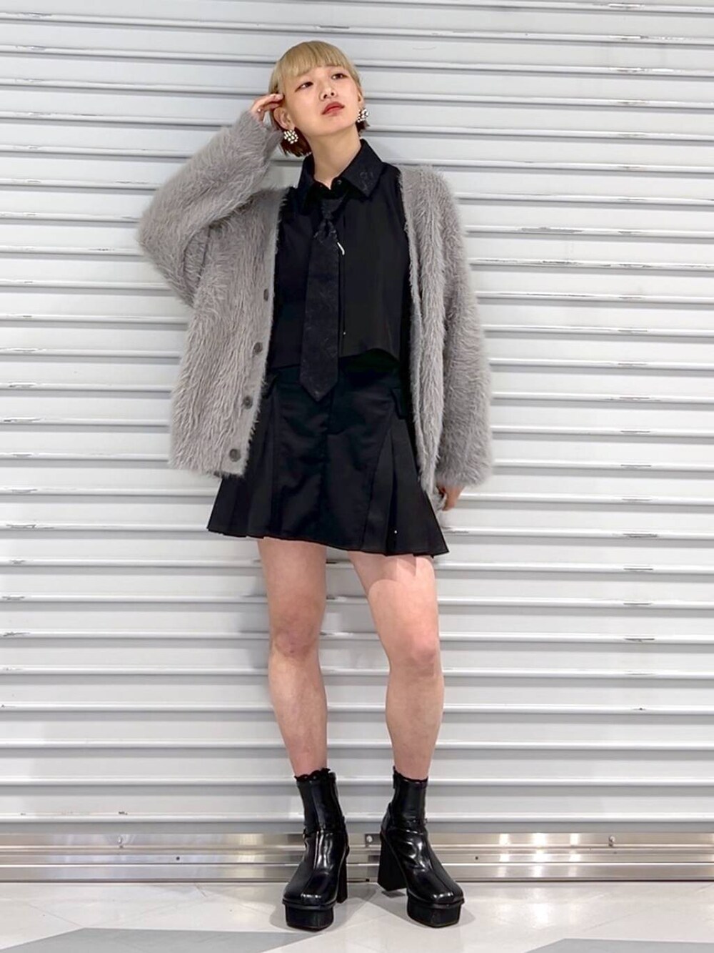 ブラック系のシャツ/ブラウス、グレー系のカーディガン/ボレロ、ブラック系のブーツを着用したレディースの秋コーディネートの2枚目の写真