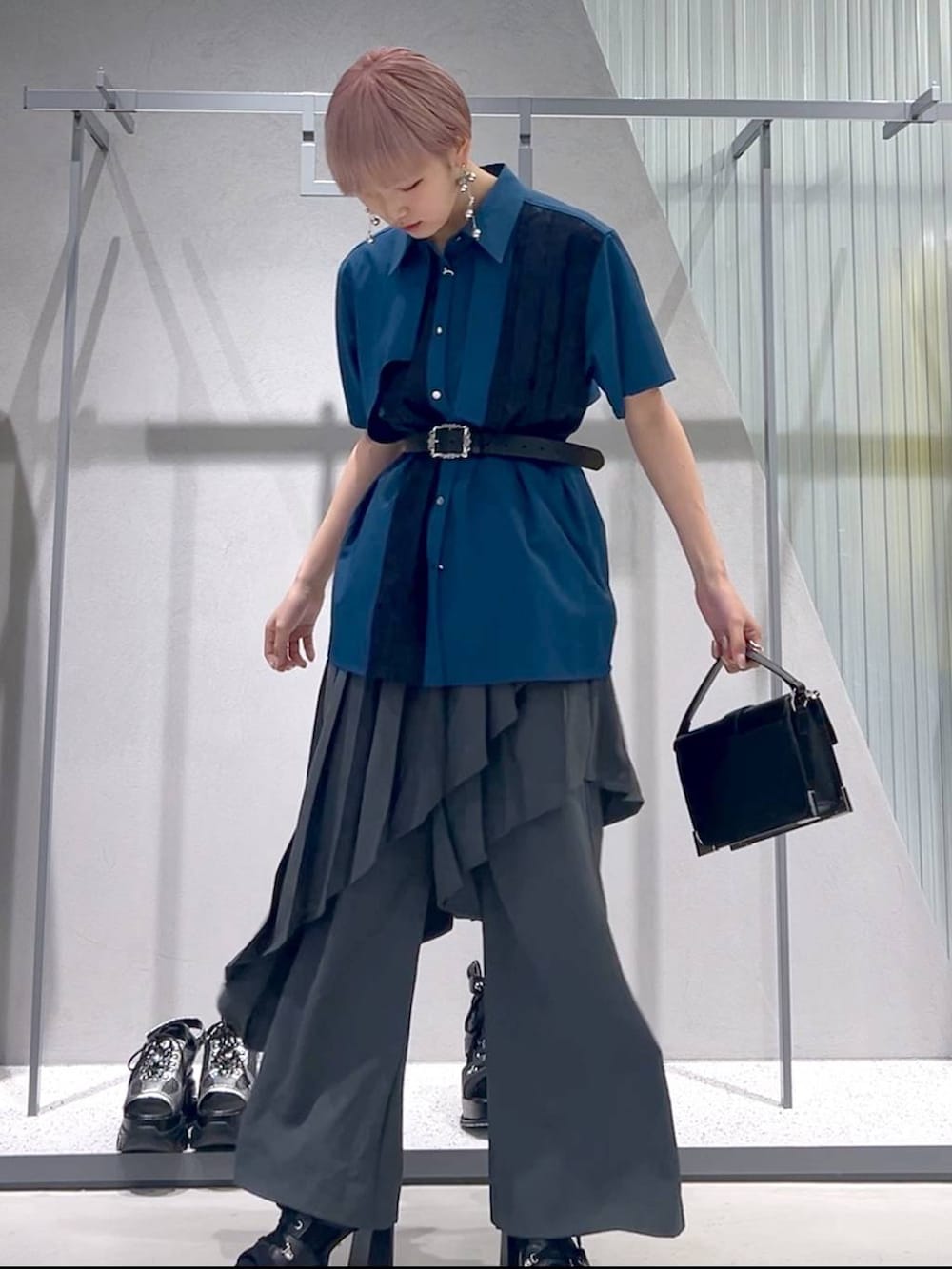 ブラック系のショルダーバッグ、ブラック系のブーツ、ブルー系のシャツ/ブラウスを着用したレディースの春コーディネートの2枚目の写真