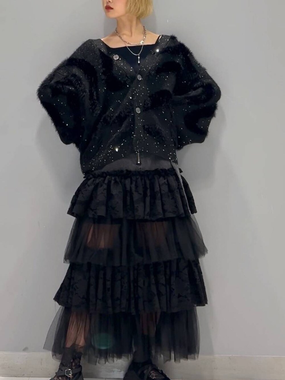 ブラック系のカーディガン/ボレロ、ブラック系のデニムスカート、シルバー系のネックレスを着用したレディースの秋コーディネートの4枚目の写真