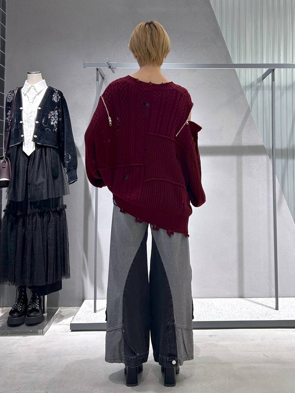 ブラック系のショルダーバッグ、ブラック系のデニムパンツ、ブルー系のタンクトップを着用したレディースの秋コーディネートの3枚目の写真