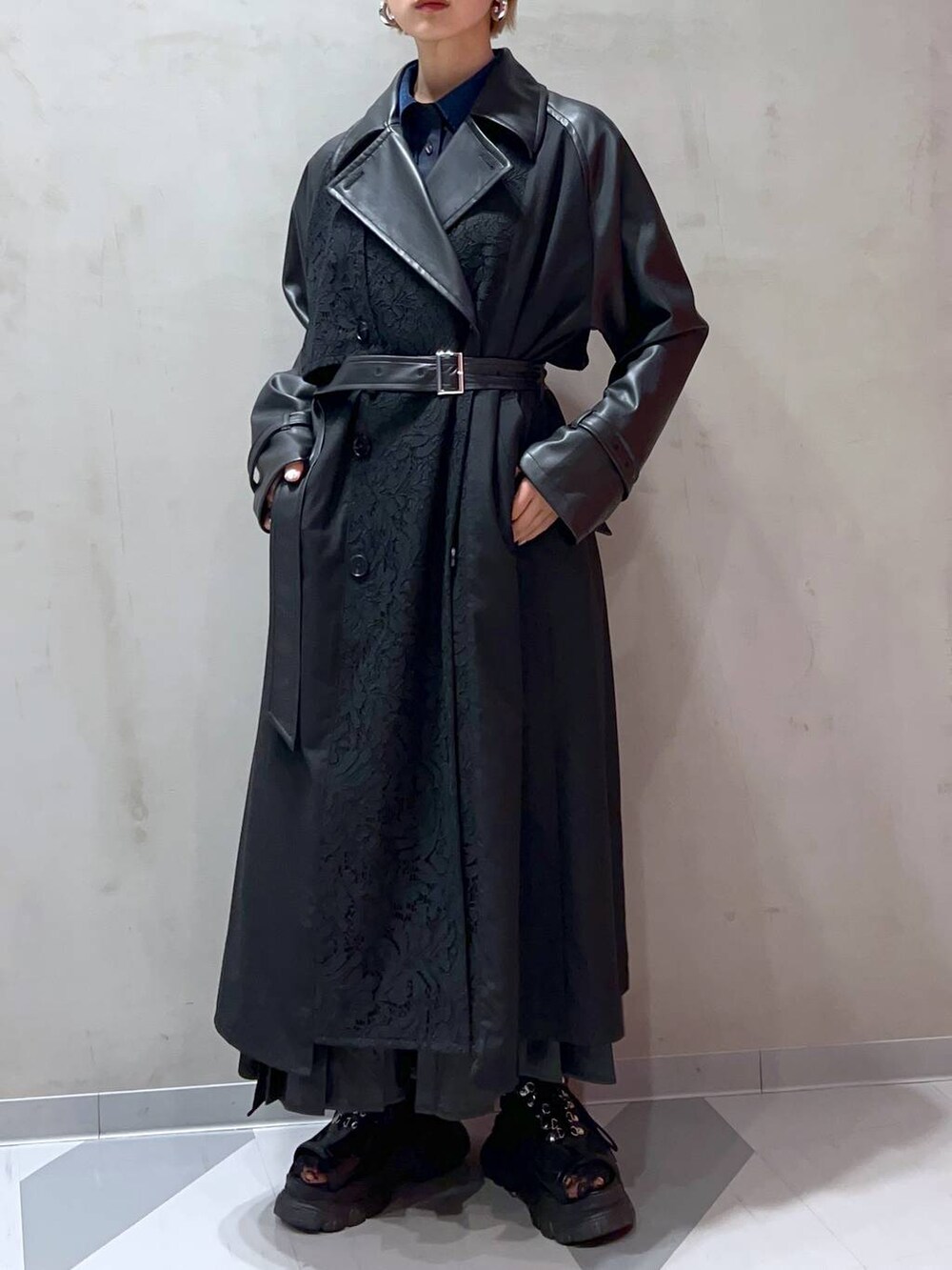 ブラック系のスカート、ブルー系のシャツ/ブラウス、ブラック系のトレンチコートを着用したレディースの秋コーディネートの7枚目の写真