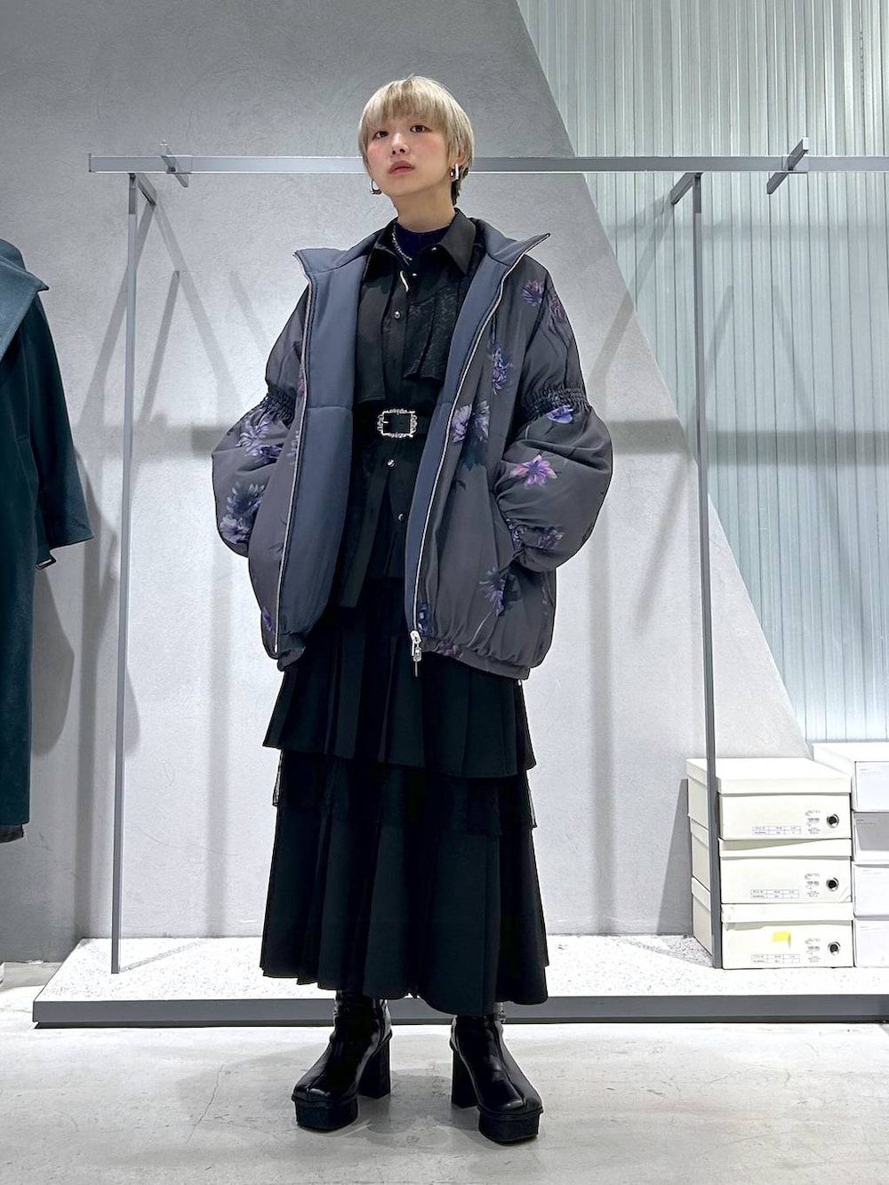 パープル系のTシャツ/カットソー、グレー系のブーツ、ブラック系のスカートを着用したレディースの冬コーディネートの6枚目の写真