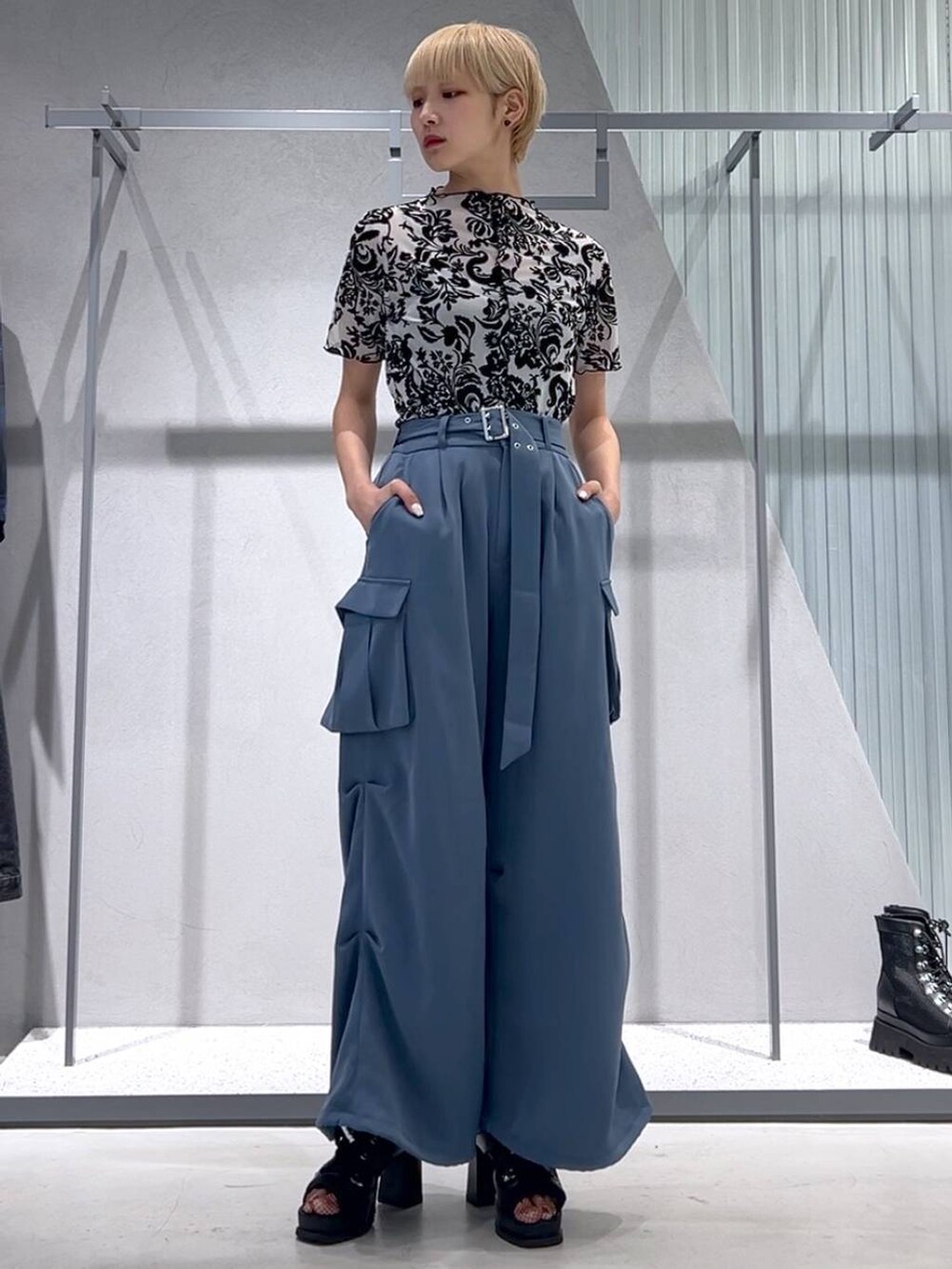 ブルー系のカーゴパンツ、ブラック系のブーツ、ホワイト系のテーラードジャケットを着用したレディースの春コーディネートの5枚目の写真