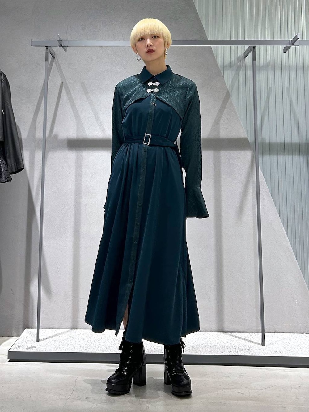 ブラック系のブーツ、グリーン系のワンピースを着用したレディースの秋コーディネートの2枚目の写真