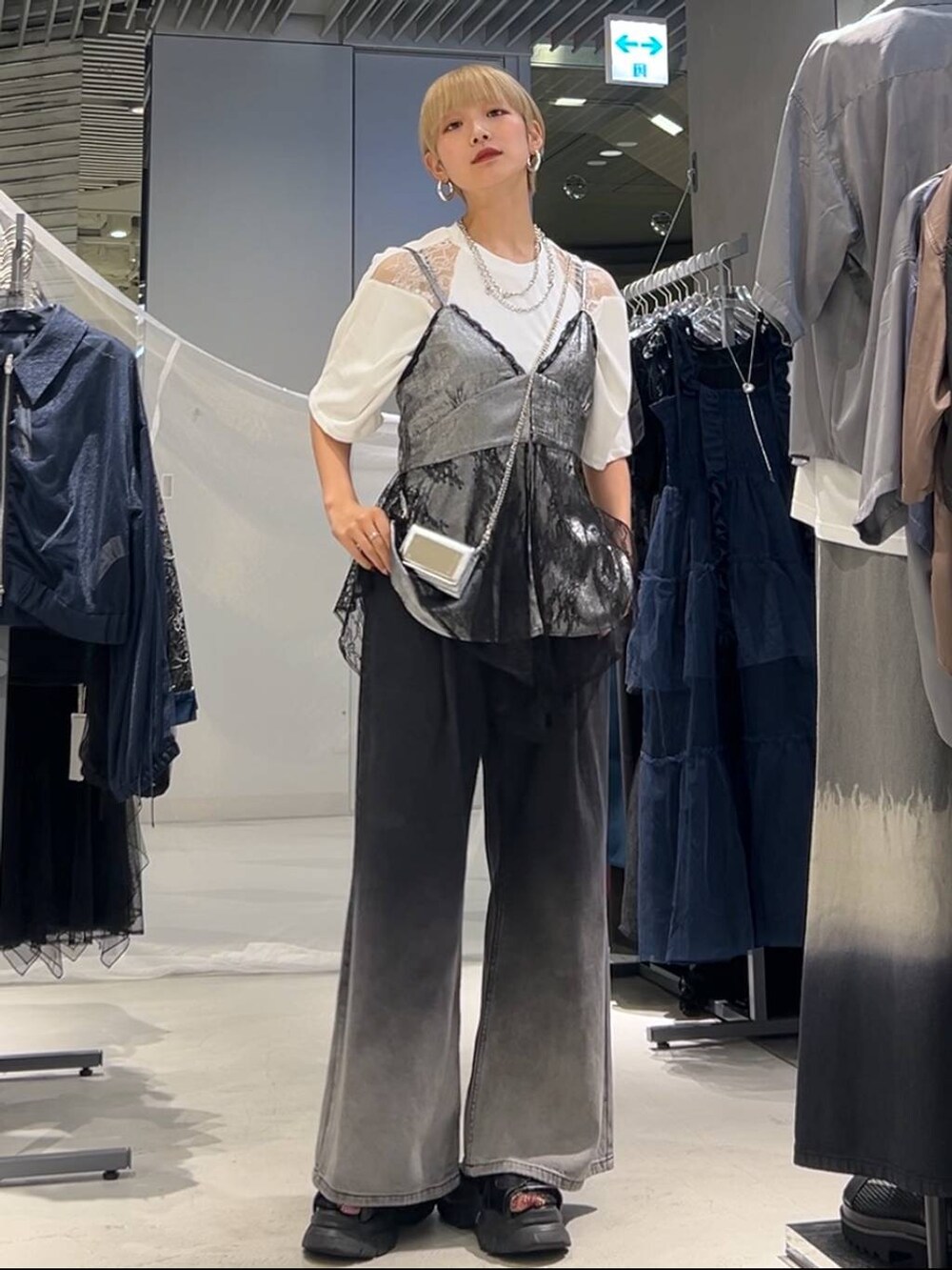 ブラック系のサンダル、ホワイト系のTシャツ/カットソー、ブラック系のデニムパンツを着用したレディースの夏コーディネートの2枚目の写真