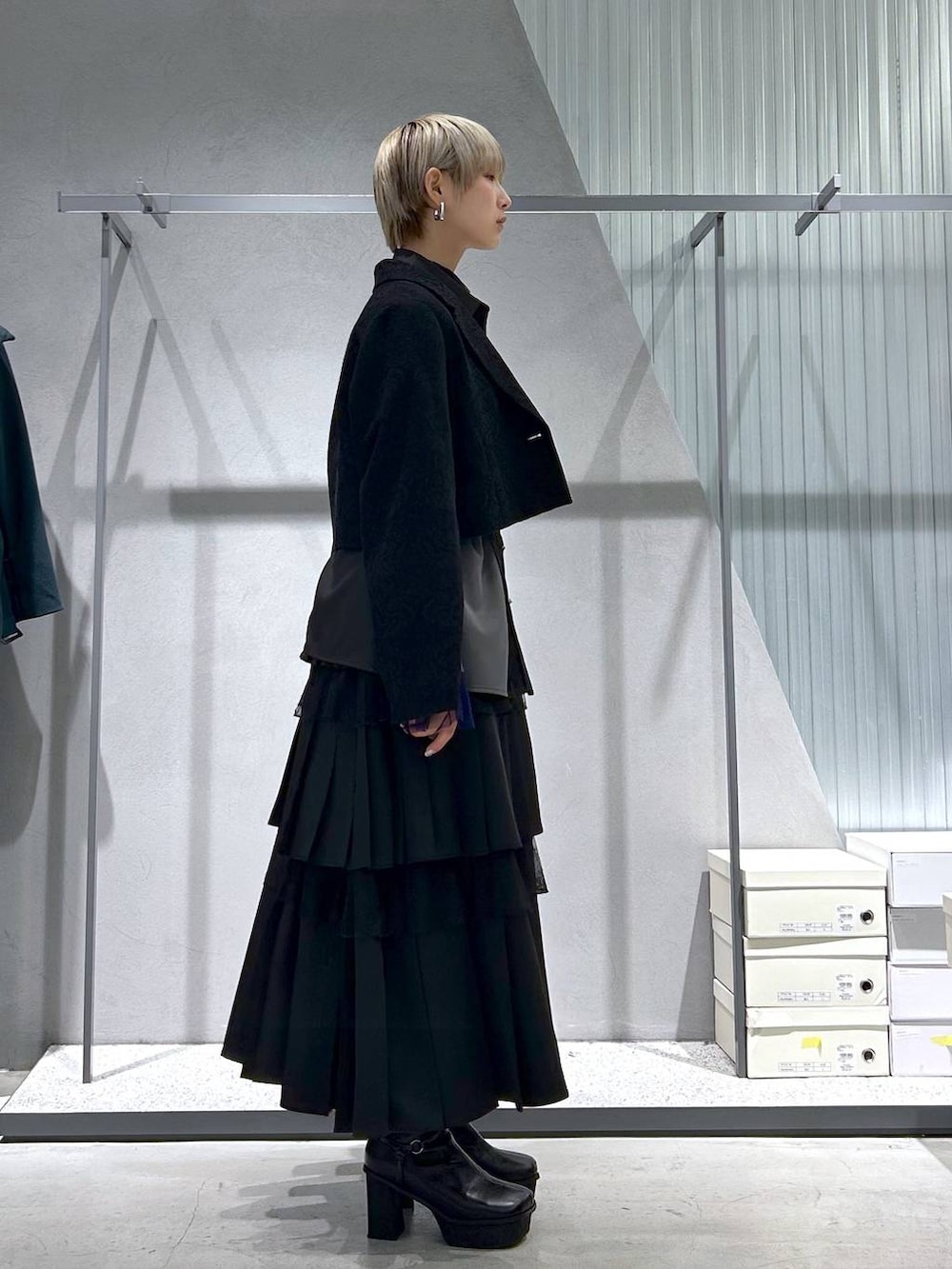 パープル系のTシャツ/カットソー、グレー系のブーツ、ブラック系のテーラードジャケットを着用したレディースの冬コーディネートの2枚目の写真