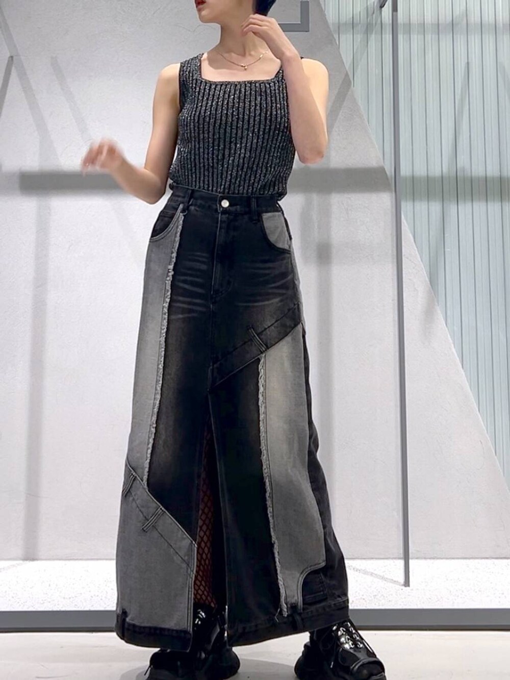 ブラック系のタンクトップ、ブラック系のサンダル、ブラック系のデニムスカートを着用したレディースの春コーディネートの4枚目の写真