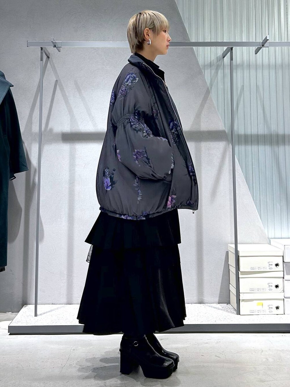 パープル系のTシャツ/カットソー、グレー系のブーツ、ブラック系のスカートを着用したレディースの冬コーディネートの2枚目の写真