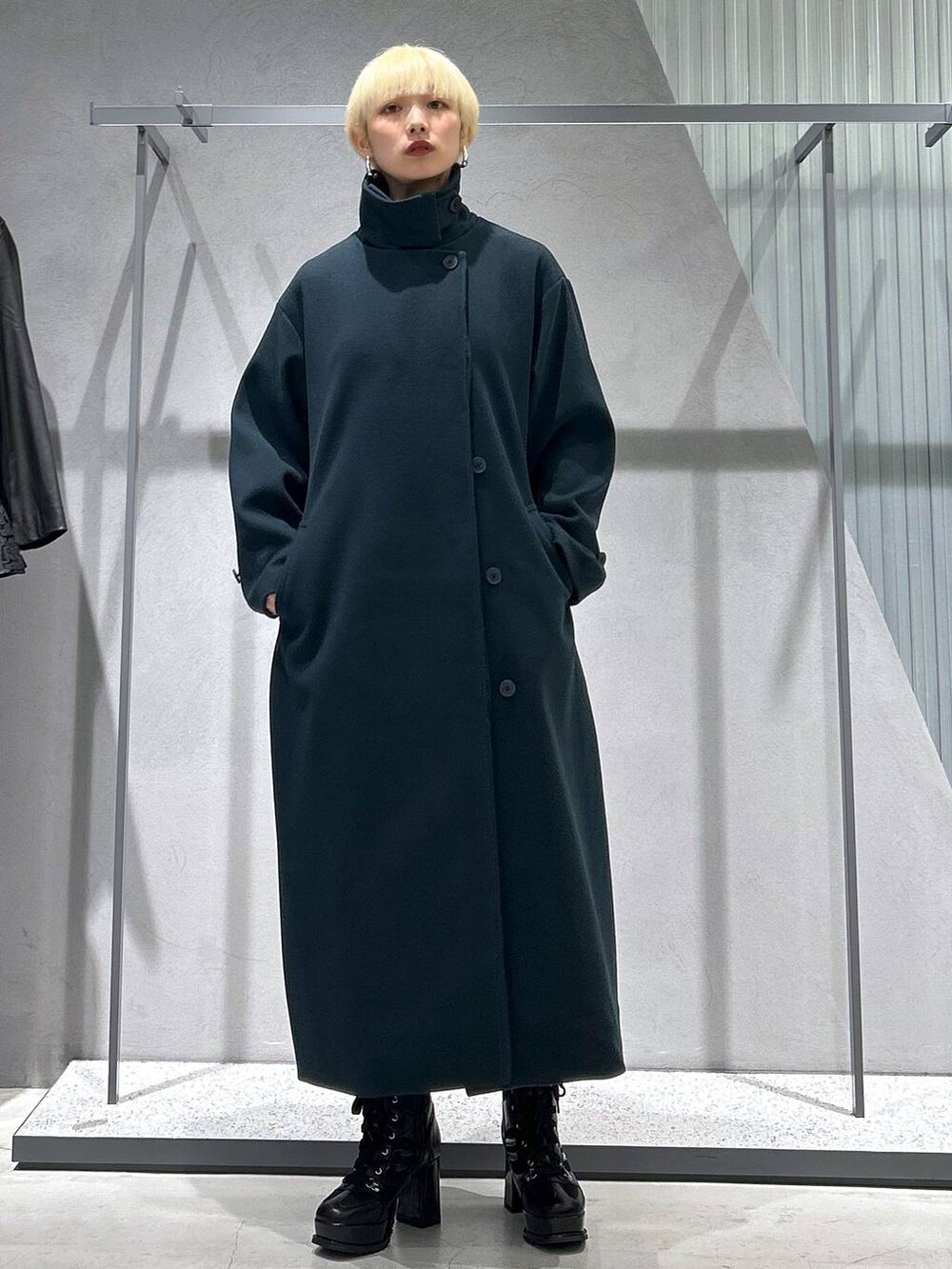 グリーン系のチェスターコート、ブラック系のブーツ、グリーン系のスウェットを着用したレディースの秋コーディネートの2枚目の写真