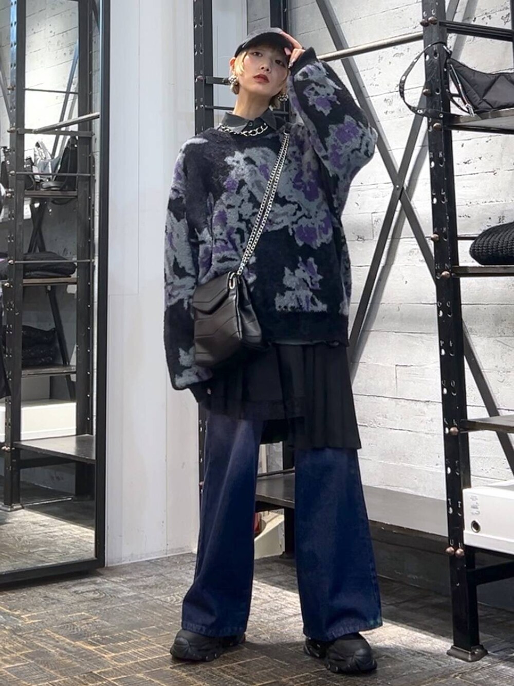 パープル系のデニムパンツ、ブラック系のニット/セーター、ブラック系のブーツを着用したレディースの冬コーディネートの4枚目の写真