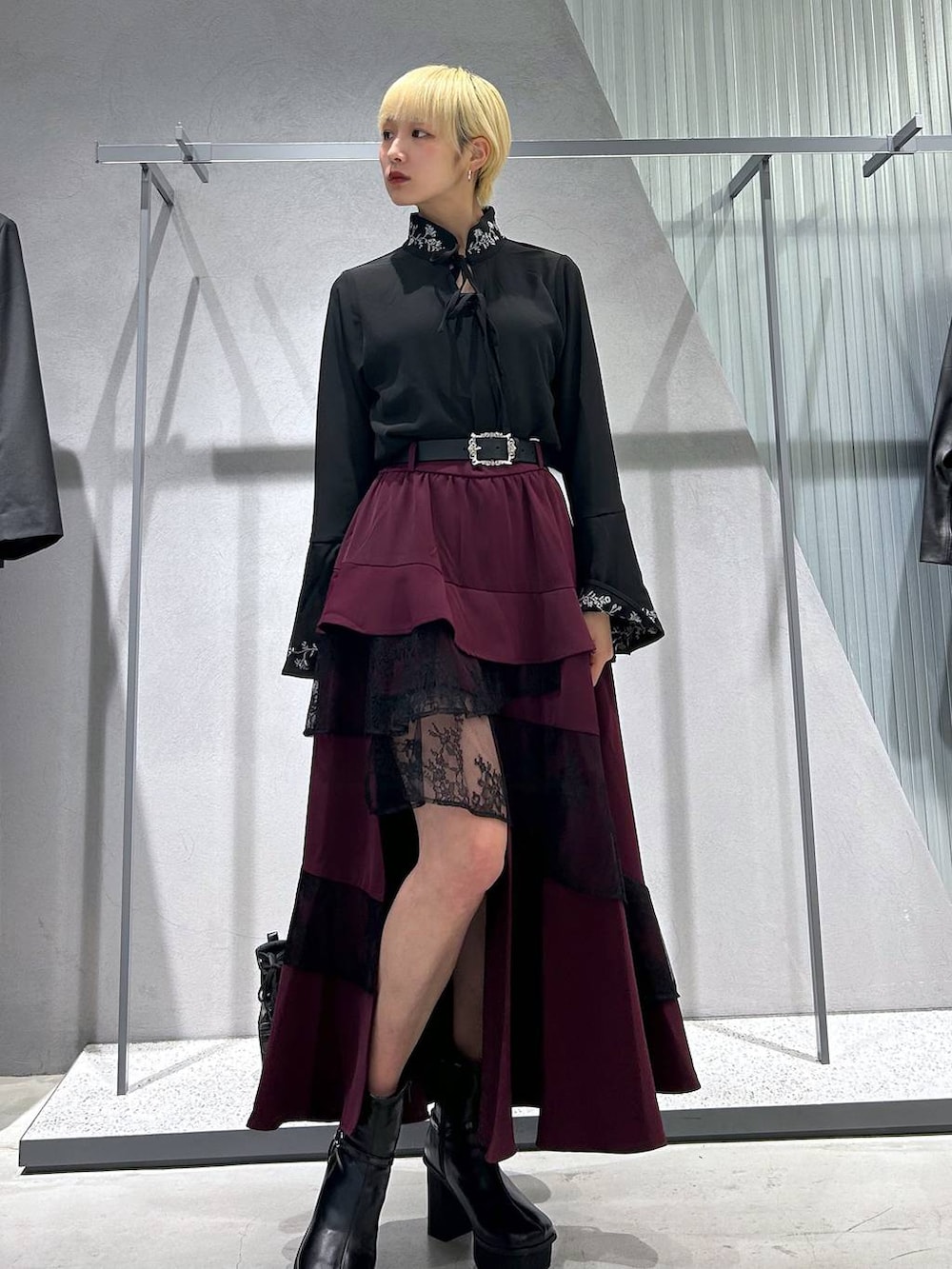 グレー系のブーツ、ブラック系のテーラードジャケット、ブラック系のシャツ/ブラウスを着用したレディースの秋コーディネートの2枚目の写真