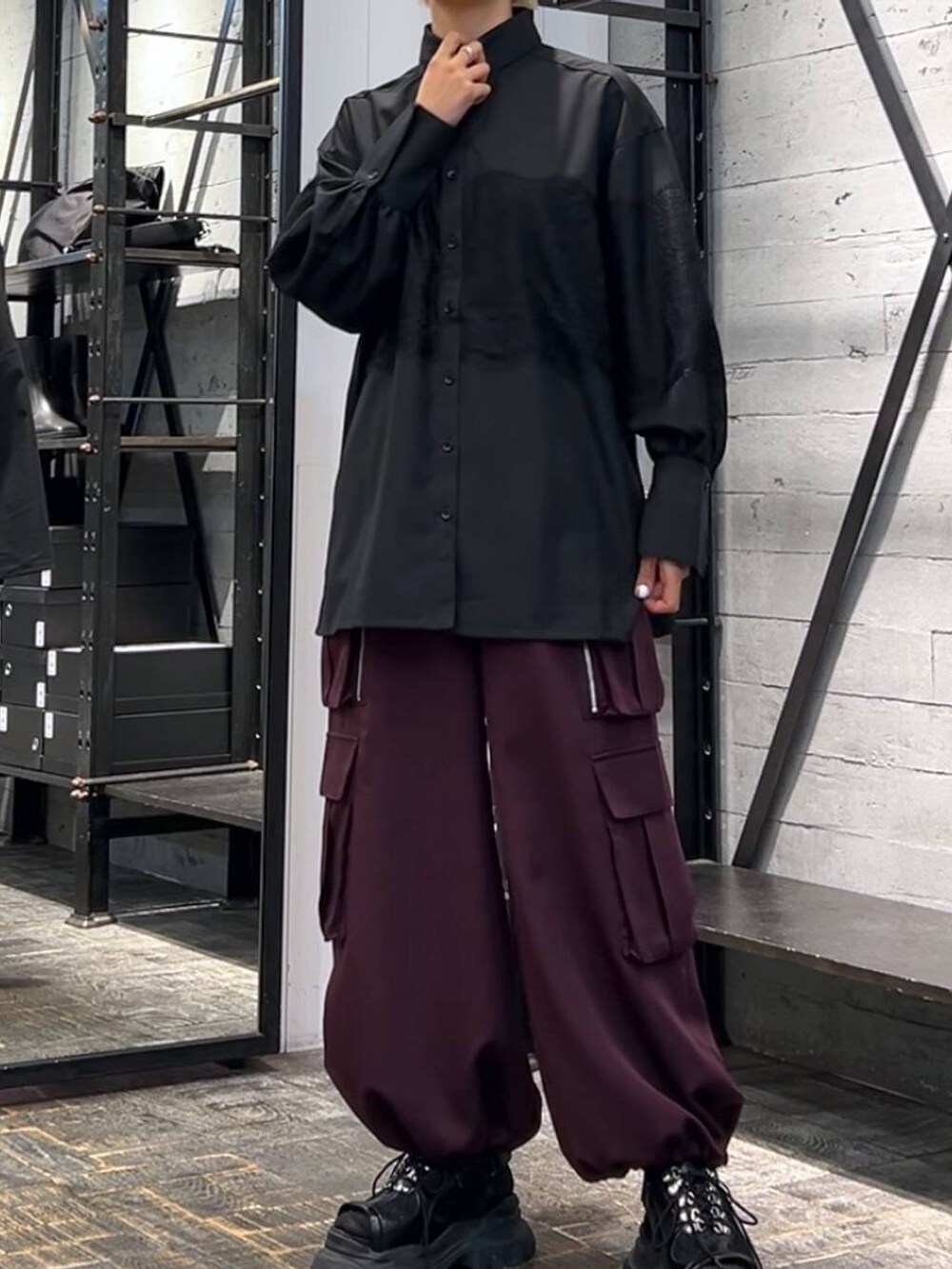 ブラック系のサンダル、レッド系のカーゴパンツ、ブラック系のシャツ/ブラウスを着用したレディースの秋コーディネートの4枚目の写真