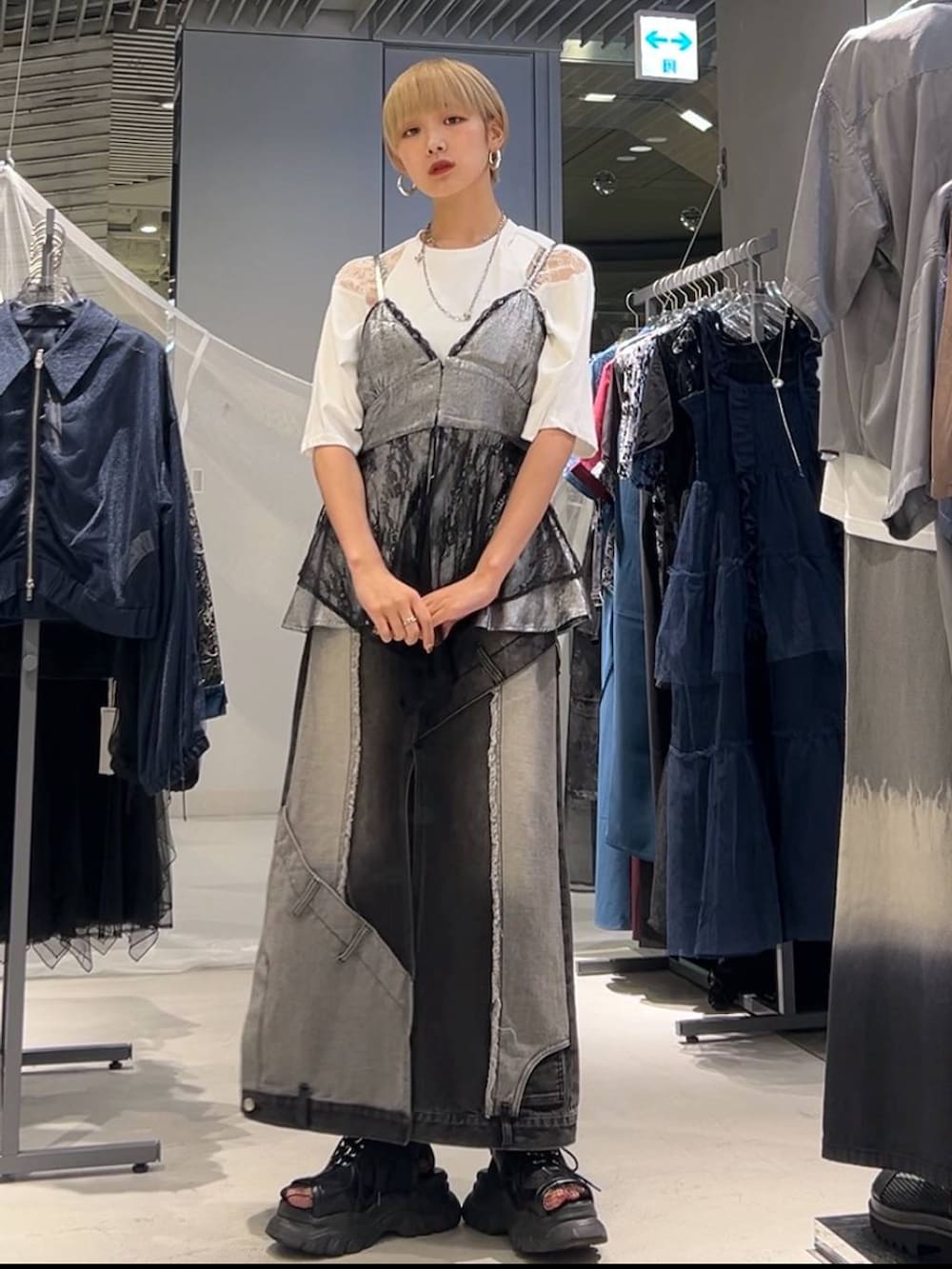 ブラック系のサンダル、ホワイト系のTシャツ/カットソー、ブラック系のデニムスカートを着用したレディースの夏コーディネートの2枚目の写真