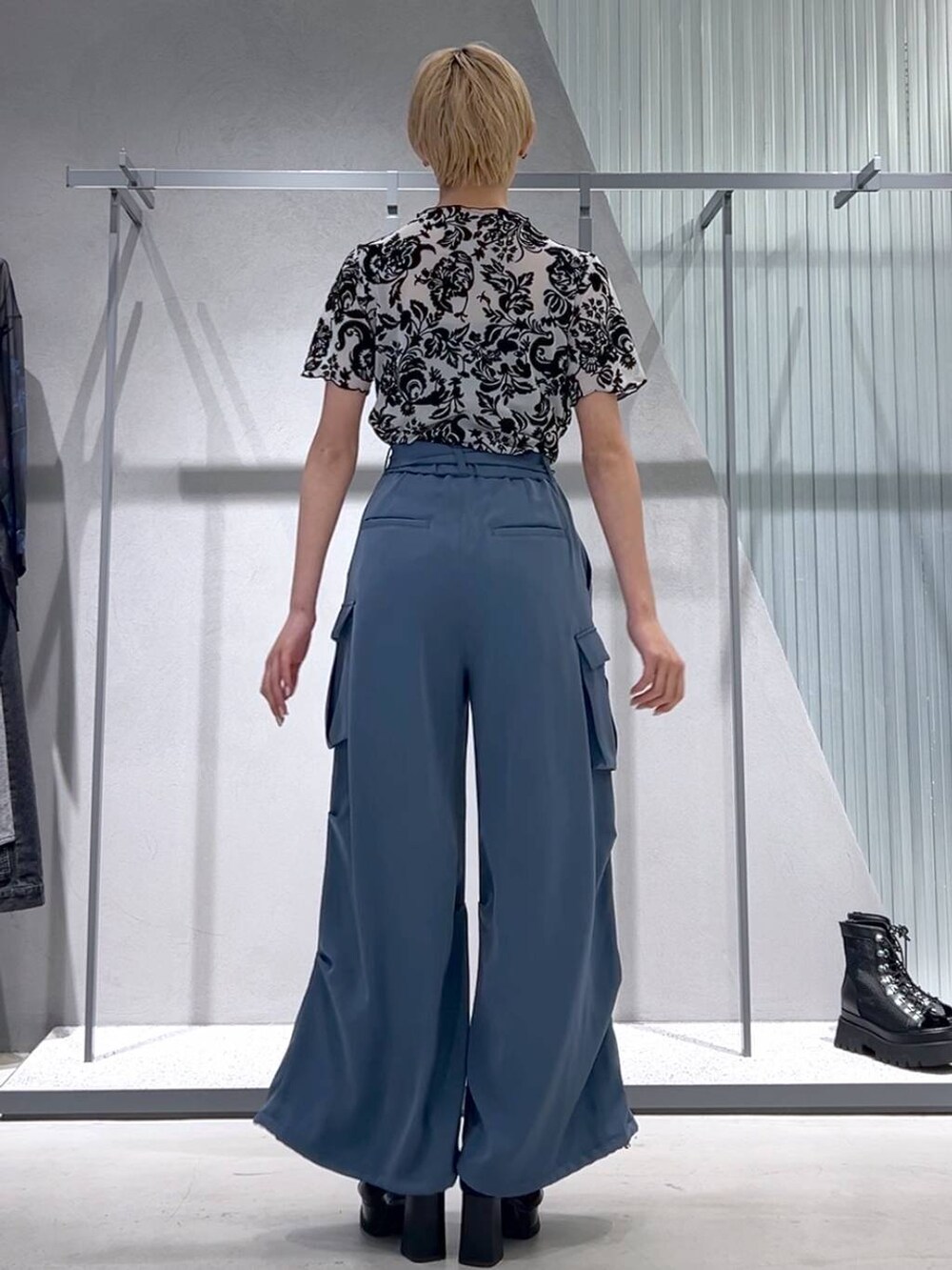 ブルー系のカーゴパンツ、ブラック系のブーツ、ホワイト系のテーラードジャケットを着用したレディースの春コーディネートの3枚目の写真