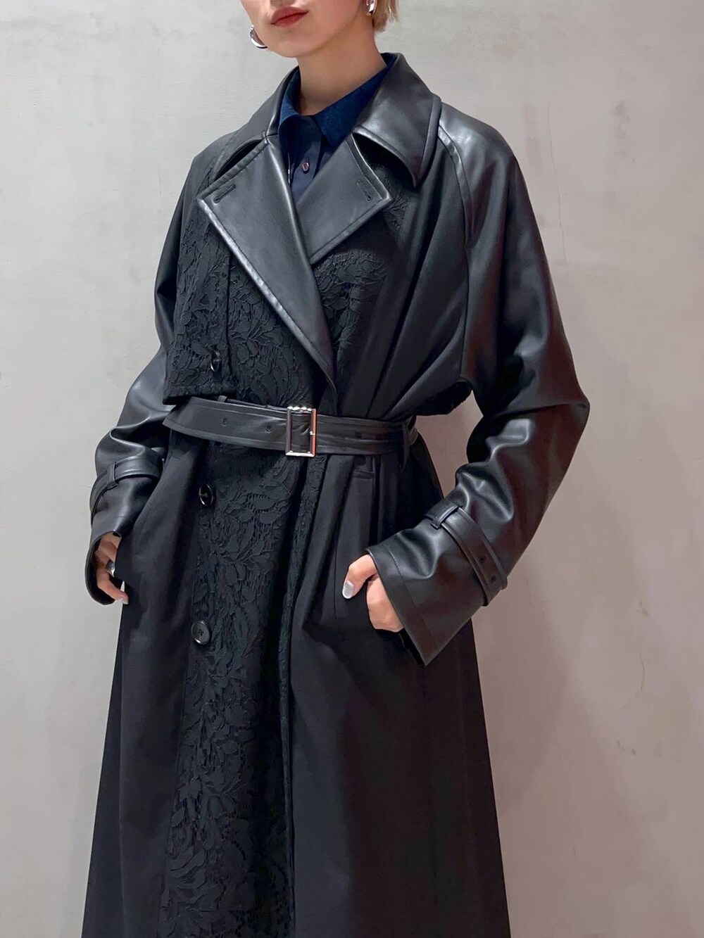 ブラック系のスカート、ブルー系のシャツ/ブラウス、ブラック系のトレンチコートを着用したレディースの秋コーディネートの3枚目の写真