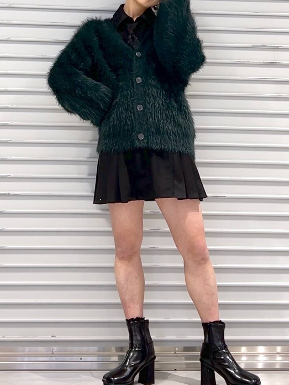 ブラック系のシャツ/ブラウス、グリーン系のカーディガン/ボレロ、ブラック系のブーツを着用したレディースの秋コーディネートの4枚目の写真