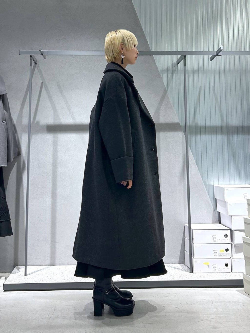 グレー系のチェスターコート、パープル系のカーディガン/ボレロ、グレー系のブーツを着用したレディースの秋コーディネートの3枚目の写真