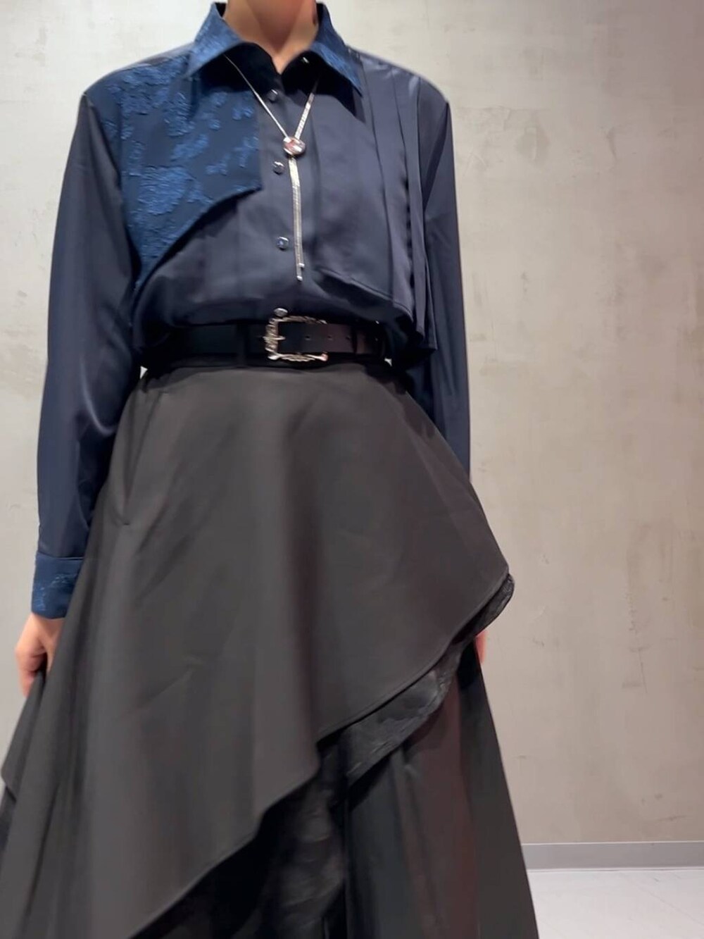 ブラック系のスカート、ブルー系のシャツ/ブラウス、ブラック系のトレンチコートを着用したレディースの秋コーディネートの9枚目の写真