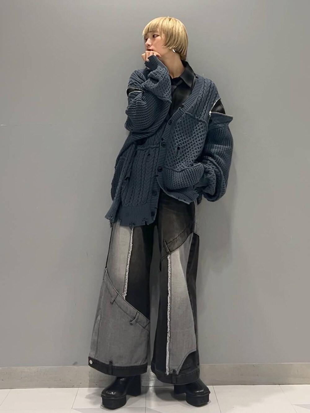 ブラック系のデニムパンツ、ブルー系のカーディガン/ボレロ、ブラック系のブーツを着用したレディースの秋コーディネートの4枚目の写真