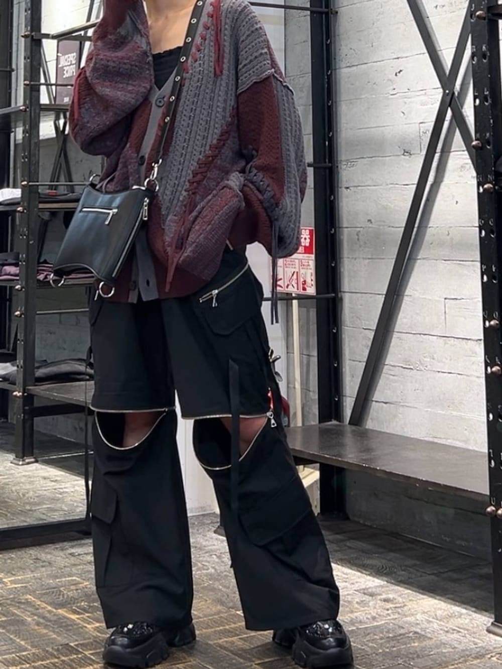 レッド系のカーディガン/ボレロ、ブラック系のカーゴパンツ、ブラック系のスニーカーを着用したレディースの秋コーディネートの6枚目の写真