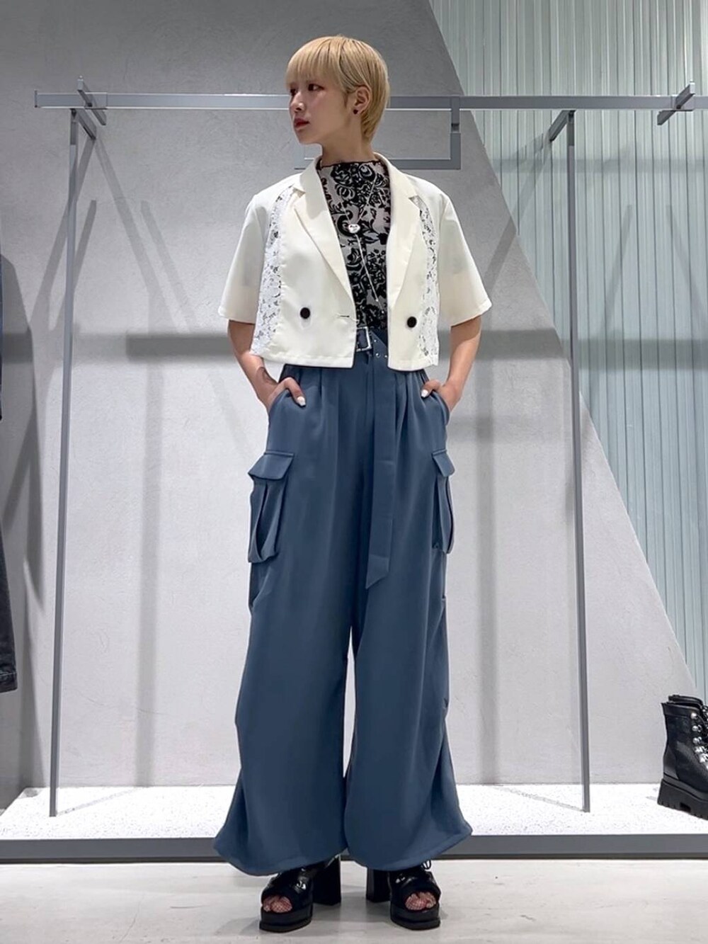 ブルー系のカーゴパンツ、ブラック系のブーツ、ホワイト系のテーラードジャケットを着用したレディースの春コーディネートの7枚目の写真