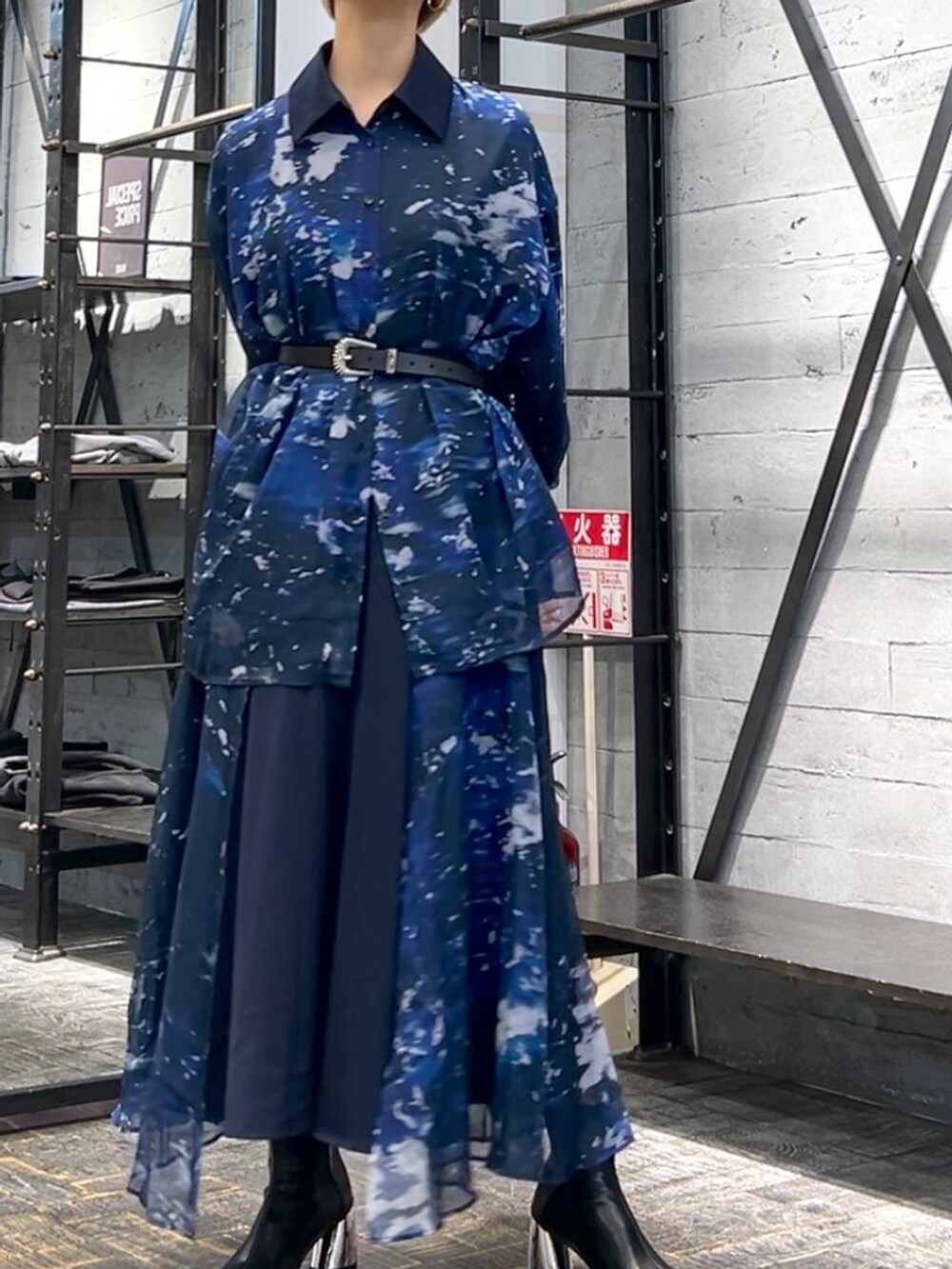 ブラック系のハンドバッグ、ブラック系のブーツ、ブルー系のスカートを着用したレディースの秋コーディネートの3枚目の写真